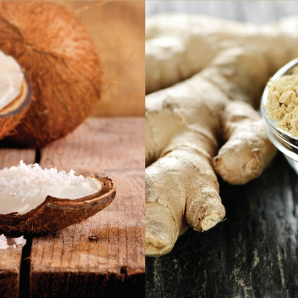 Coconut with coconut meat and a bowl of coconut meat on a wooden surface, next to ginger root on a dark surface.