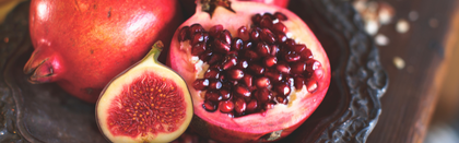 Pomegranate and fig on a dark surface