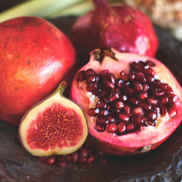 Pomegranate and figs on a dark surface