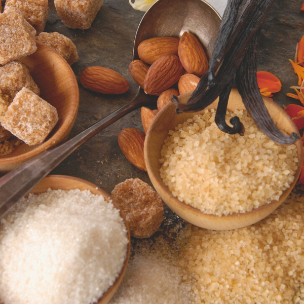 Assorted types of sugar and vanilla beans on a rustic surface