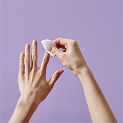 Person applying Zoya Remove Plus to their hand against a purple background