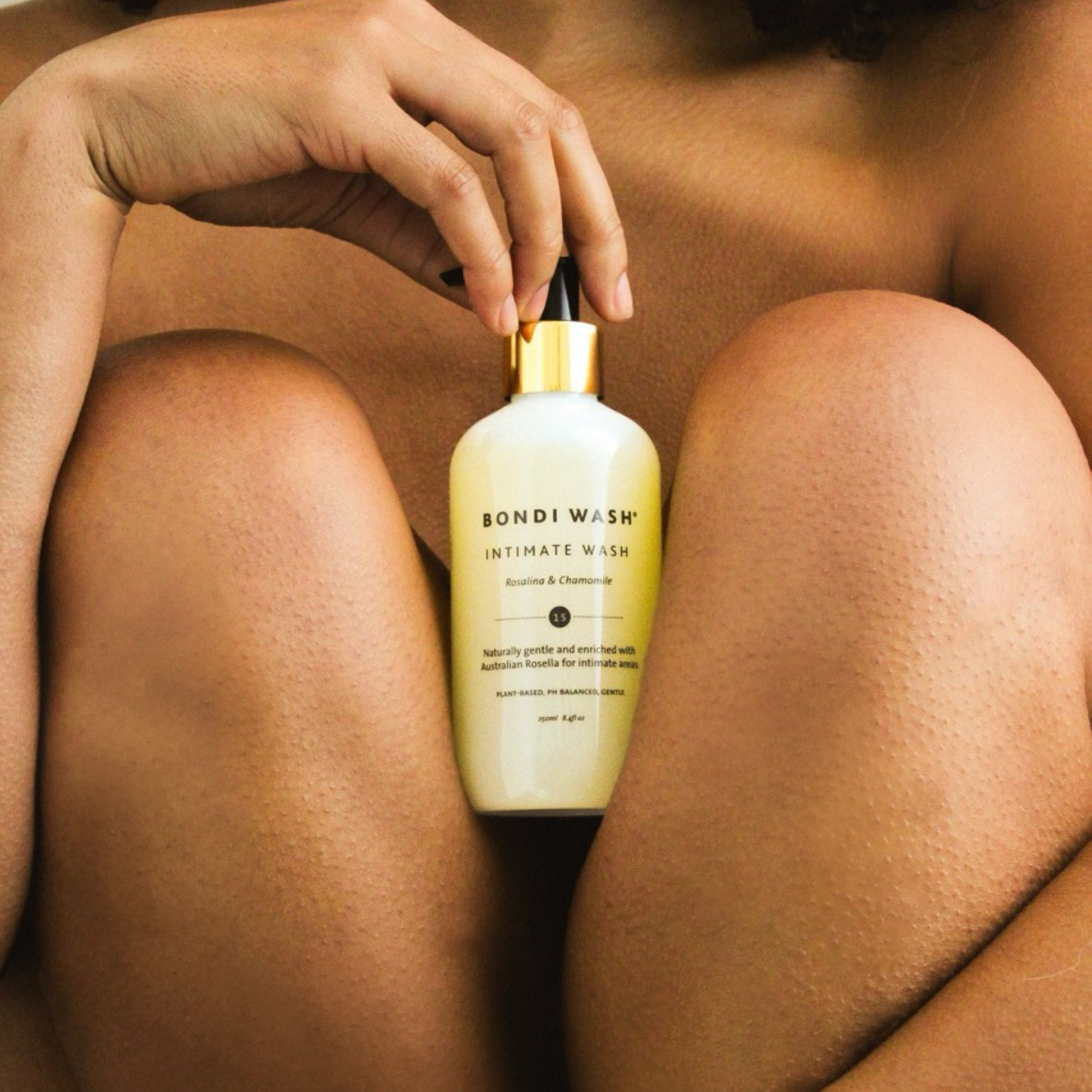 Person holding a bottle of Bondi Wash Intimate Wash between their legs.