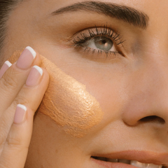 Close-up of a person applying makeup to their face with a focus on the eye area.