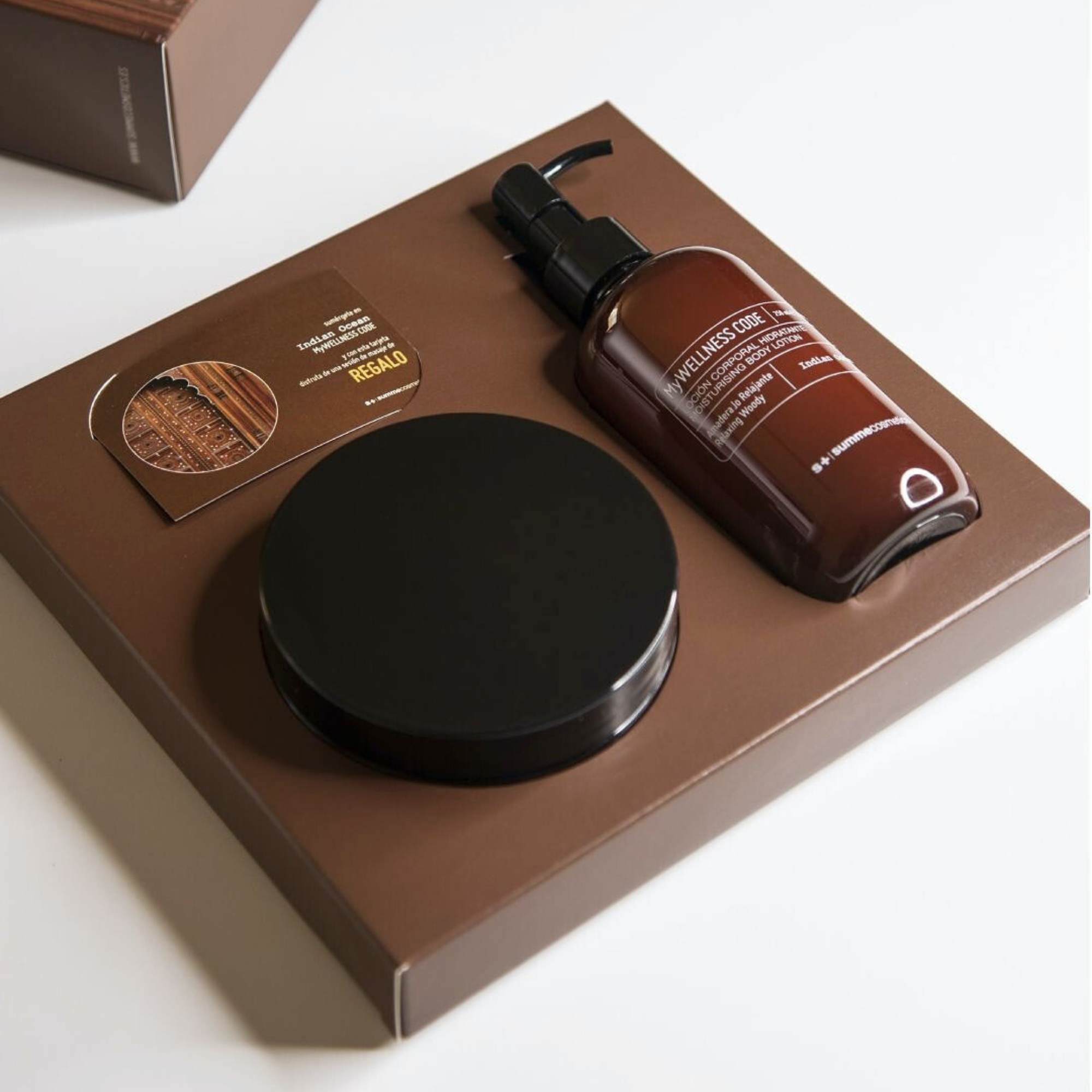 Skincare product set with bottle, round container, and card on a brown tray
