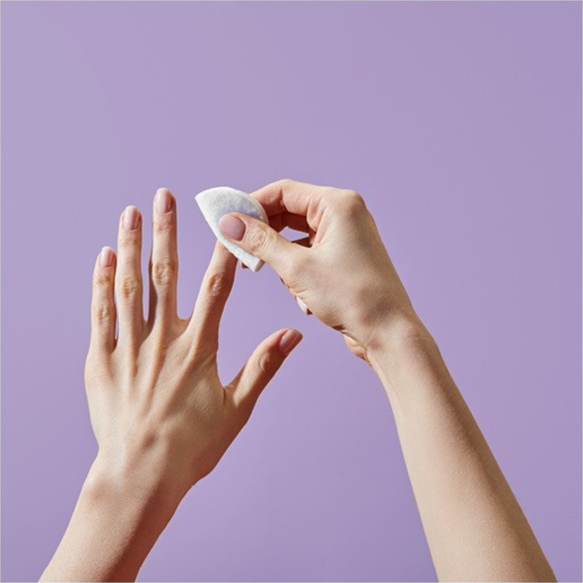 Person applying Zoya Remove Plus  to their hand against a purple background